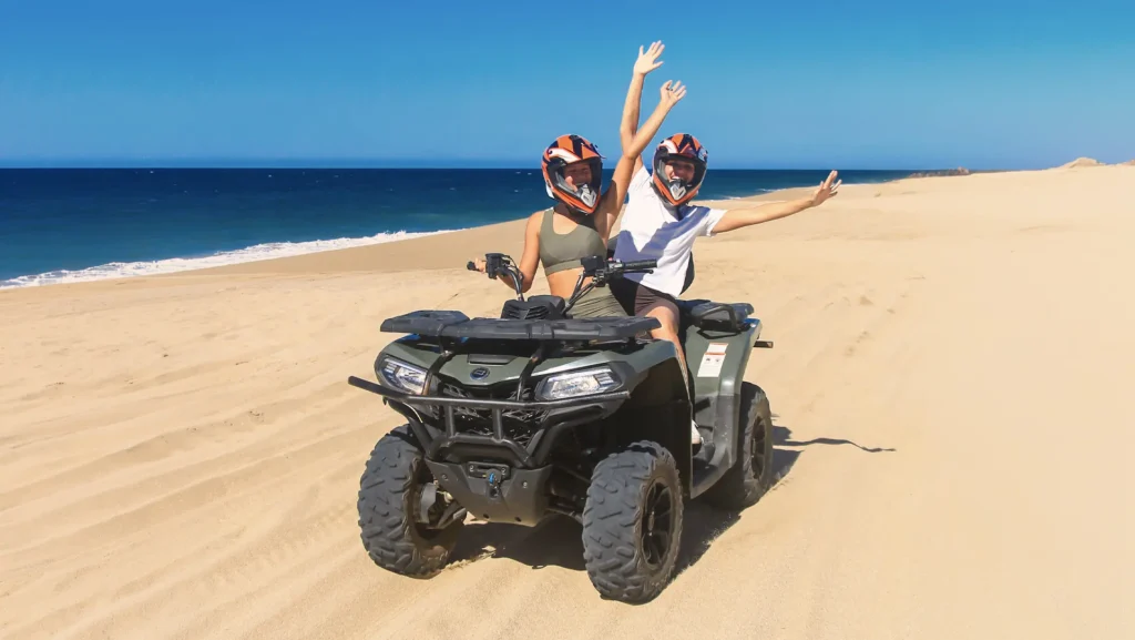 Couple riding an ATV on the beach in Cabo San Lucas with the ocean in the background