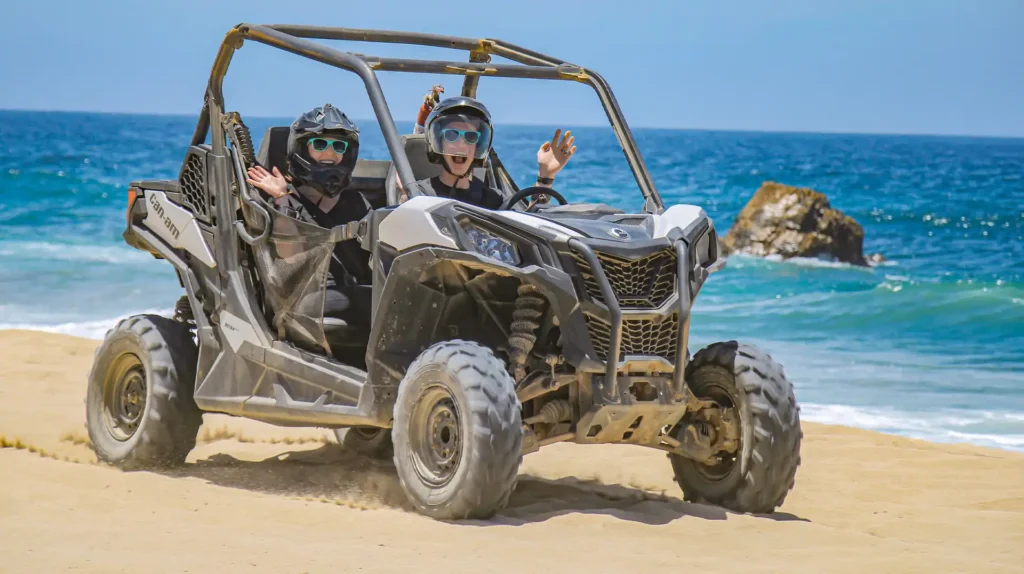 Two riders driving a Side by Side UTV by the ocean in Los Cabos