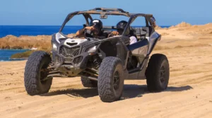 Couple riding Can-Am Maverick X3 on beach off road tour in Los Cabos
