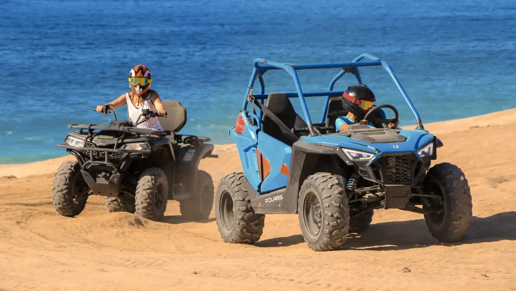 Mini UTV for kids in Los Cabos driving on beach dunes next to the ocean with ATV guide